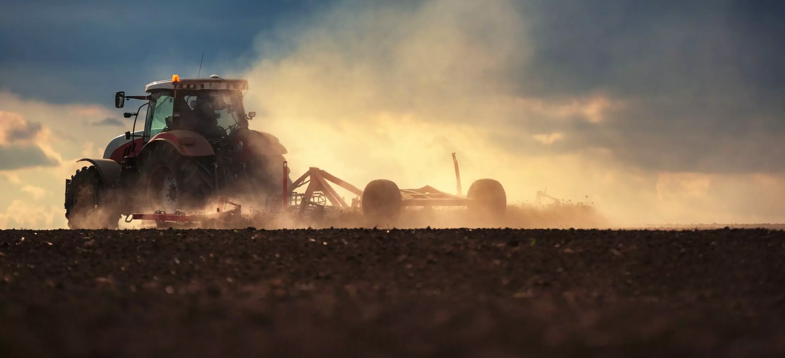 Farmer in tractor preparing land with seedbed cultivator